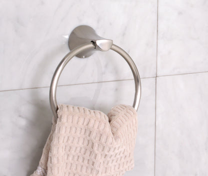 Metal towel ring with a beige towel on a tiled wall